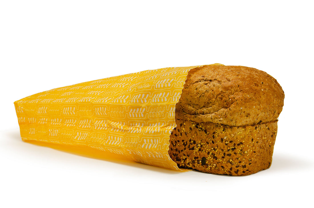 beeswax bread bag, wheat pattern, laying flat with a loaf of bread